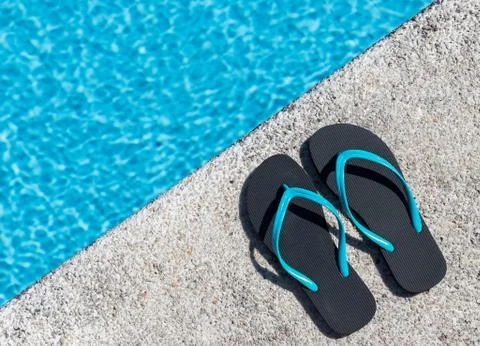 Flip flops on the edge of a pool Stock Photos