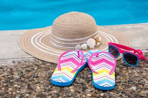 Flip flops with hat by pool Stock Photos