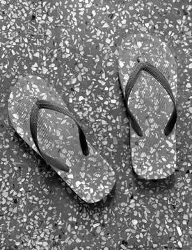 Flip flops patterned similar to the floor Stock Photos
