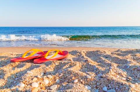 Flip flops on a sandy ocean beach Stock Photos