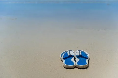 Flip Flops on a sandy ocean beach - Summer vacation concept. Stock Photos