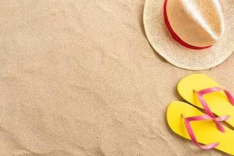 Flip flops, straw hat, on sand background. Beach vacation concept .Top view w Stock Photos