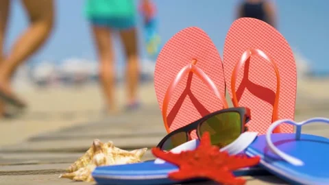 Flip flops, sunglasses and seashells on beach sand.  Stock Footage 135432344
