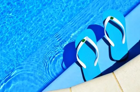 Flip-flops on the swimming pool Stock Photos