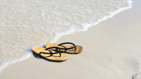 Flip flops on white sandy beach near sea waves, 4K UHD Stock Footage 88385410