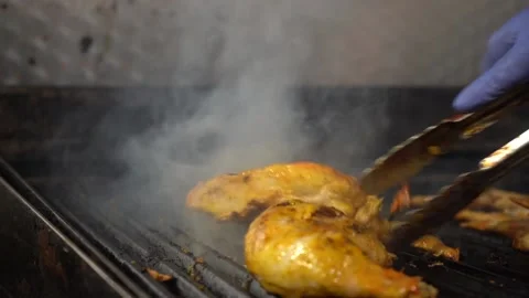 Flipping chicken on grill in slow motion Stock Footage 142881604