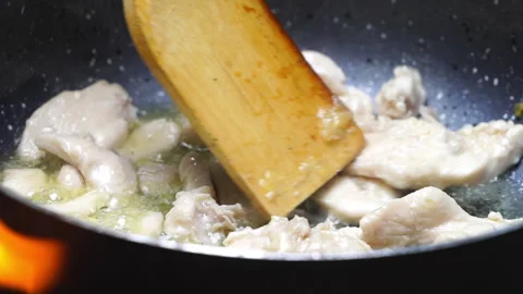 Flipping Chicken in a Pan Over a Campfire with a Spoon 動画素材 318824173