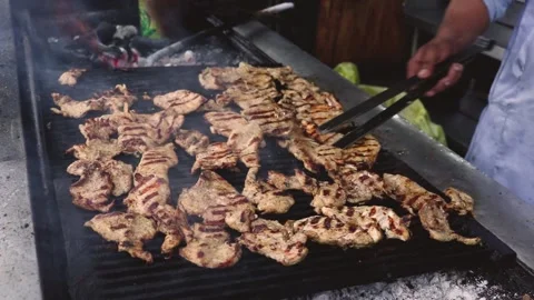 Flipping chicken steaks on a huge grill. Stock Footage 160928701