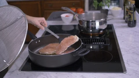 Flipping Chicken While Holding Splatter Guard Video stock 97299726