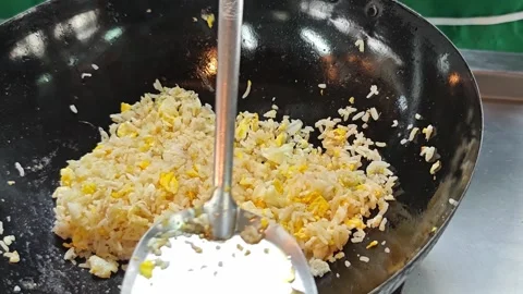 Flipping egg fried rice in a hot wok with a spatula. Stock Footage 342393542