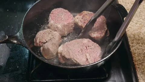Flipping Four Thick Beef Filets in a Seasoned Cast Iron Skillet Stock Footage 326092756