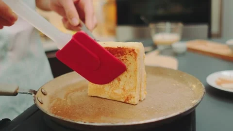Flipping fried toast in egg batter to the other side Stock-Footage 252392807