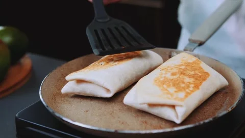 Flipping a fried tortilla on the kitchen Stock Footage 250288241