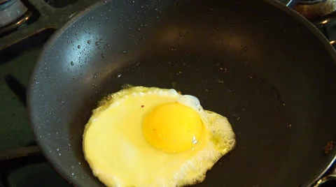 Flipping a Frying Egg in a saute Pan Stock Footage 24696130