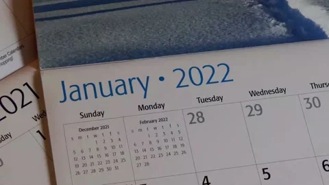 Flipping page by page through the months of a new 2022 calendar 動画素材 167780335