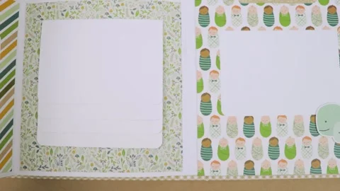 Flipping page of unique designed baby themed scrapbook layout, inside Stock Footage 281005931