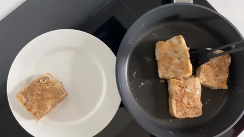Flipping pancakes onto plate for breakfast Vídeos de archivo 343864573
