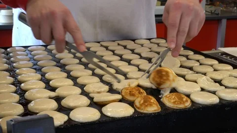 Flipping poffertjes in a mini pancake maker Video stock 93643137