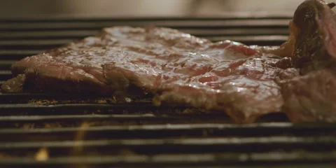 Flipping ribeye steaks on grill 스톡 동영상 247385100