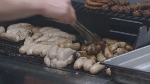Flipping sausages on a bbq Stock Footage 247331224