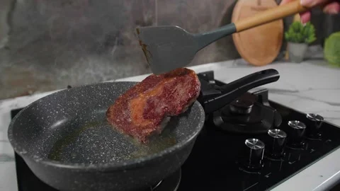Flipping a steak in a frying pan Video stock 268576500