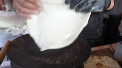 Flipping a thick layered paratha on a large flat tawa, indian street food Stock Footage 326124536