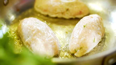 Flipping three chicken cutlets in a hot frying pan Stock Footage 333831592