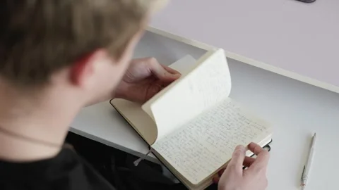 Flipping Through a Notebook – Over the Shoulder View Stock Footage 302579946