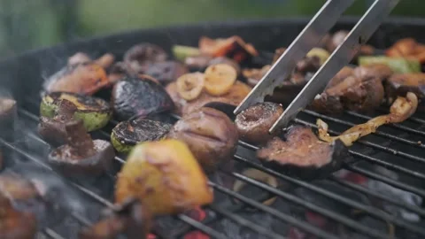 Flips delicious vegetables on a charcoal grill Stock Footage 201020360