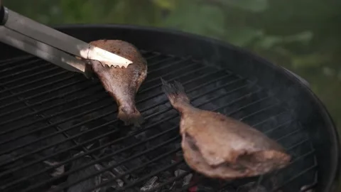 Flips dorado fish on a charcoal grill with smoke Stock Footage 201021276