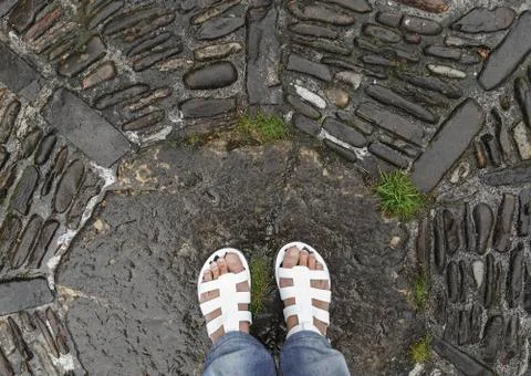 Flips flops on cobblestone pavement II Stock Photos