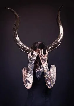 Flirting with the devil. Studio shot of a tattooed young woman. Stock Photos