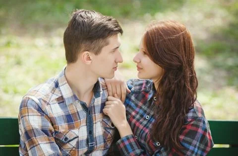 Flirting young couple on a bench 스톡 사진