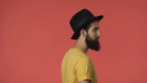 Flirty handsome bearded middle-eastern man standing backwards in yellow t-shirt Stock Footage 115777462