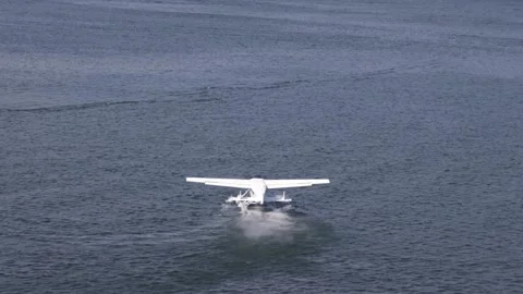 Float plane takes off from dark blue water of Vancouver Harbor Stock Footage 208239167