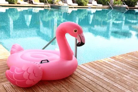 Float in shape of flamingo on wooden deck near swimming pool at luxury resort Stock Photos