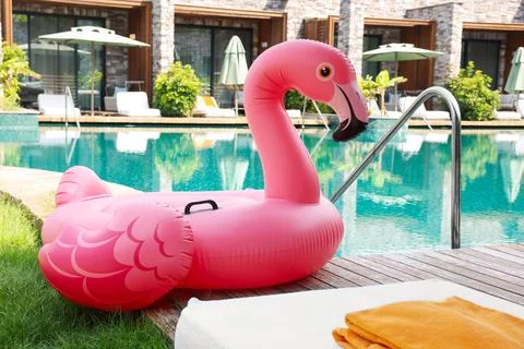 Float in shape of flamingo on wooden deck near swimming pool at luxury resort 写真素材