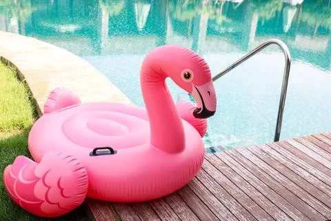 Float in shape of flamingo on wooden deck near swimming pool at luxury resort 写真素材