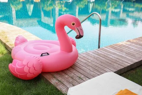 Float in shape of flamingo on wooden deck near swimming pool at luxury resort Stock Photos
