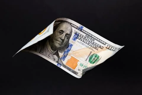 Floating 100 US Dollar Bill over Solid Black Background Stock Photos
