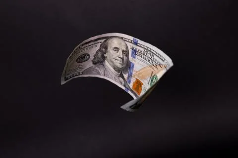 Floating 100 US Dollar Bill over Solid Black Background Stock Photos