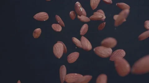 Floating almonds on a black slow motion background Stock Footage 148666474
