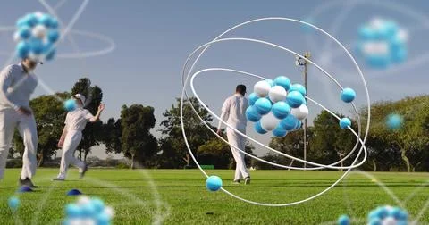 Floating atom model hovering above sports field, showing athletes in white Stock Photos