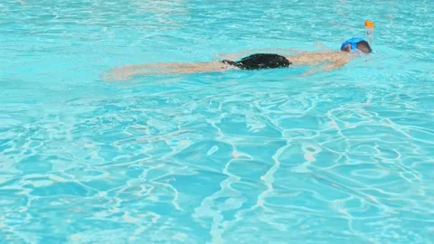 Floating boy on blue swimming pool in resort. Summer vacation, tourism concept Stock Footage 169951428