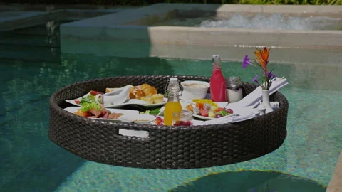 Floating breakfast tray in luxury pool with tropical flowers, fresh Stock Footage 278153769