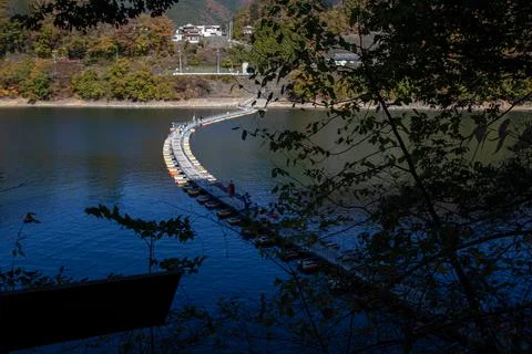 Floating bridge of drum containers on lake in Japan, sunny autumn day Stock Photos