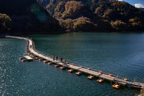 Floating bridge of drum containers on lake in Japan, sunny autumn day Foto stock