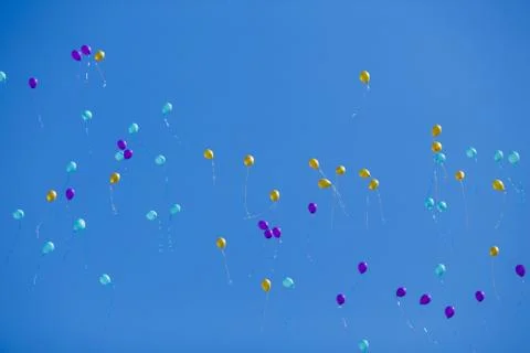 Floating bright multicolored balloons high in the blue cloudless Foto stock