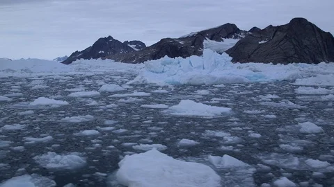 Floating broken ice and icebergs, Greenland mountains behind, Arctic Ocean Stock Footage 92111784