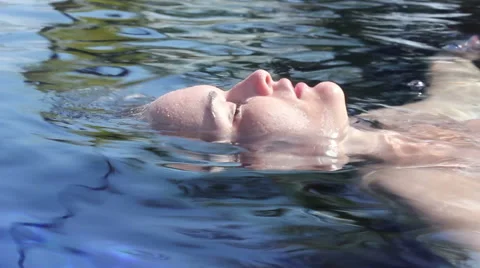 Floating Brunette in a Tropical Pool Stock Footage 53559301